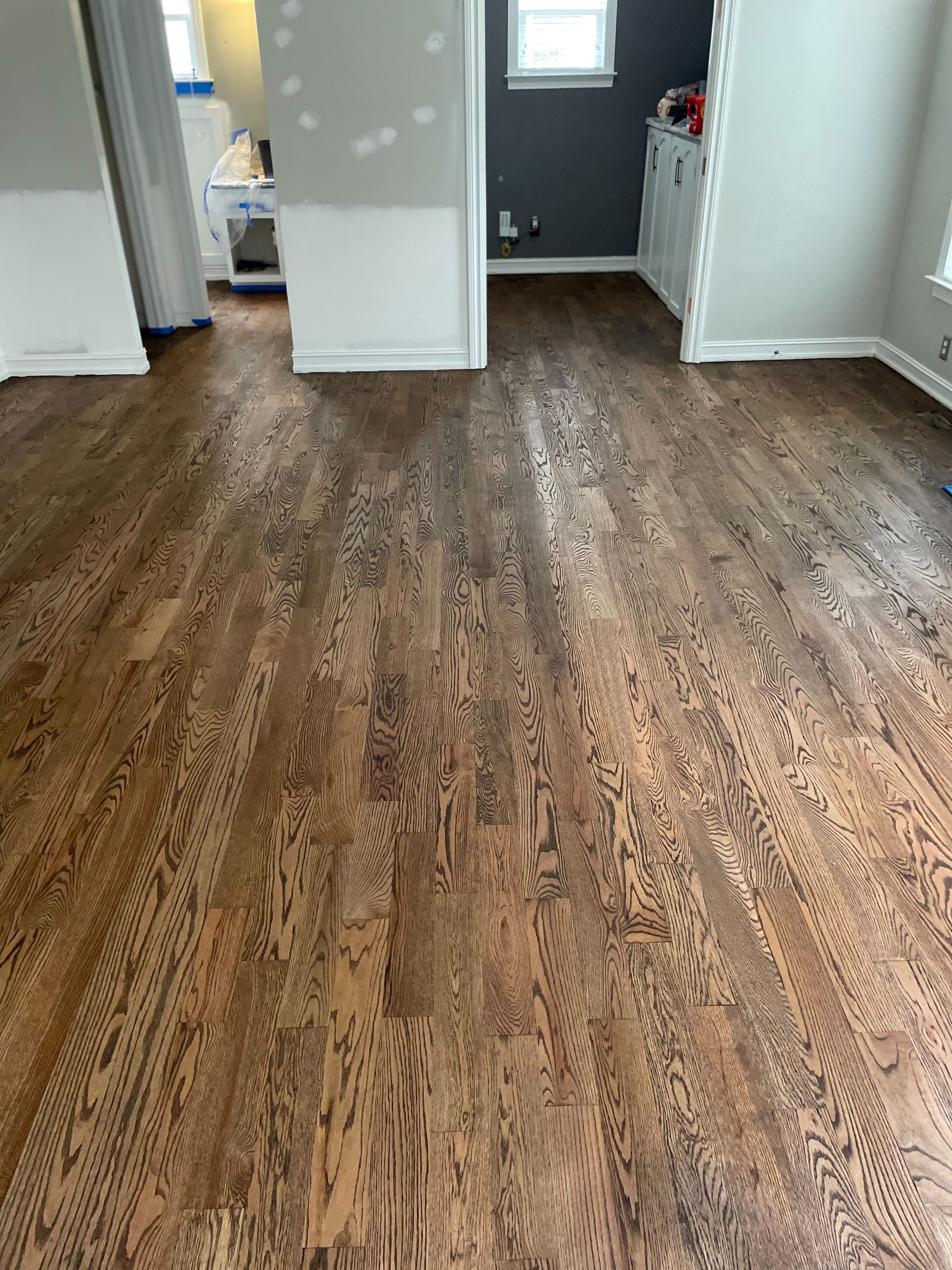 A living room with hardwood floors and a gray wall.