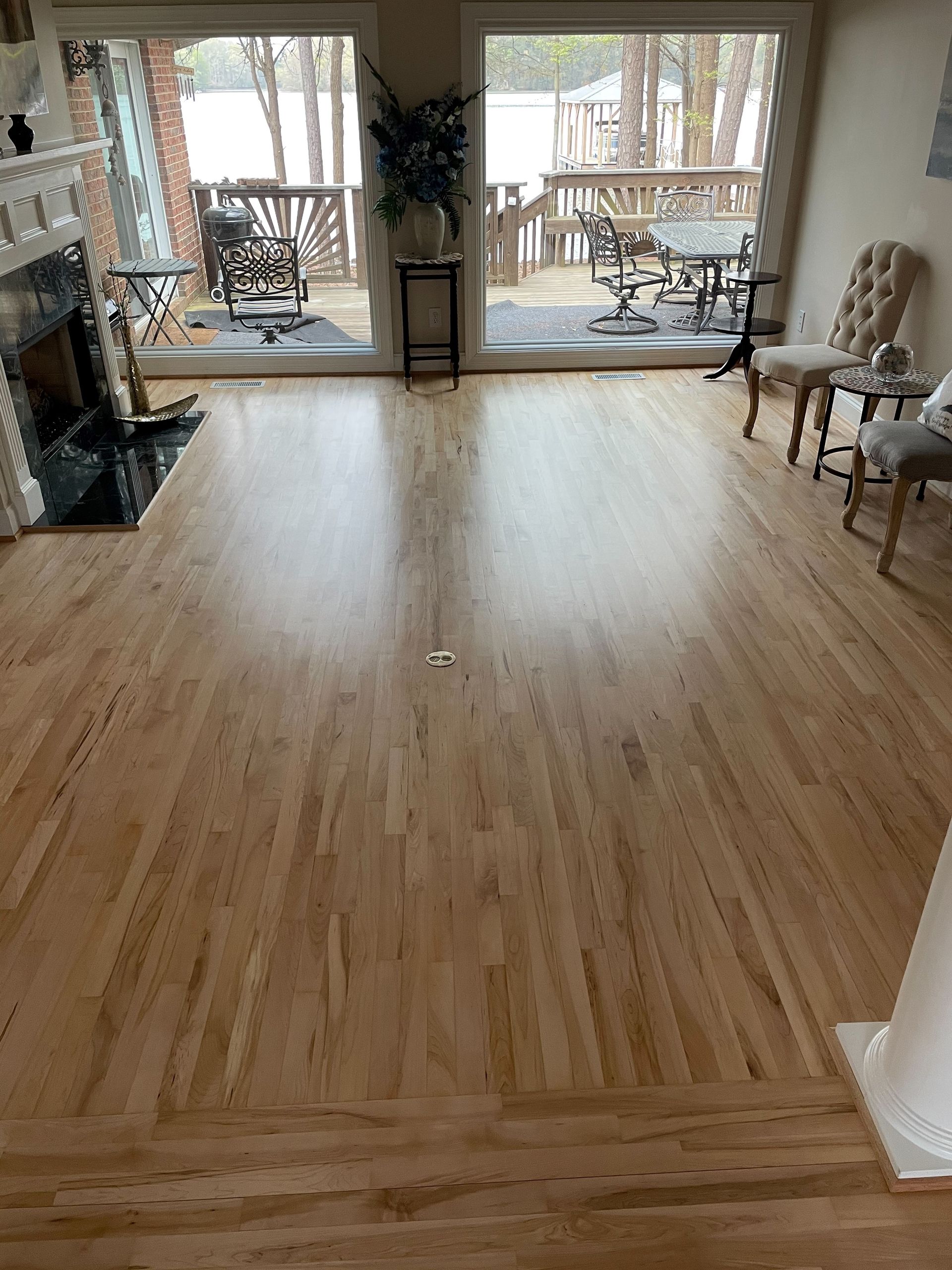 A living room with hardwood floors and a fireplace.