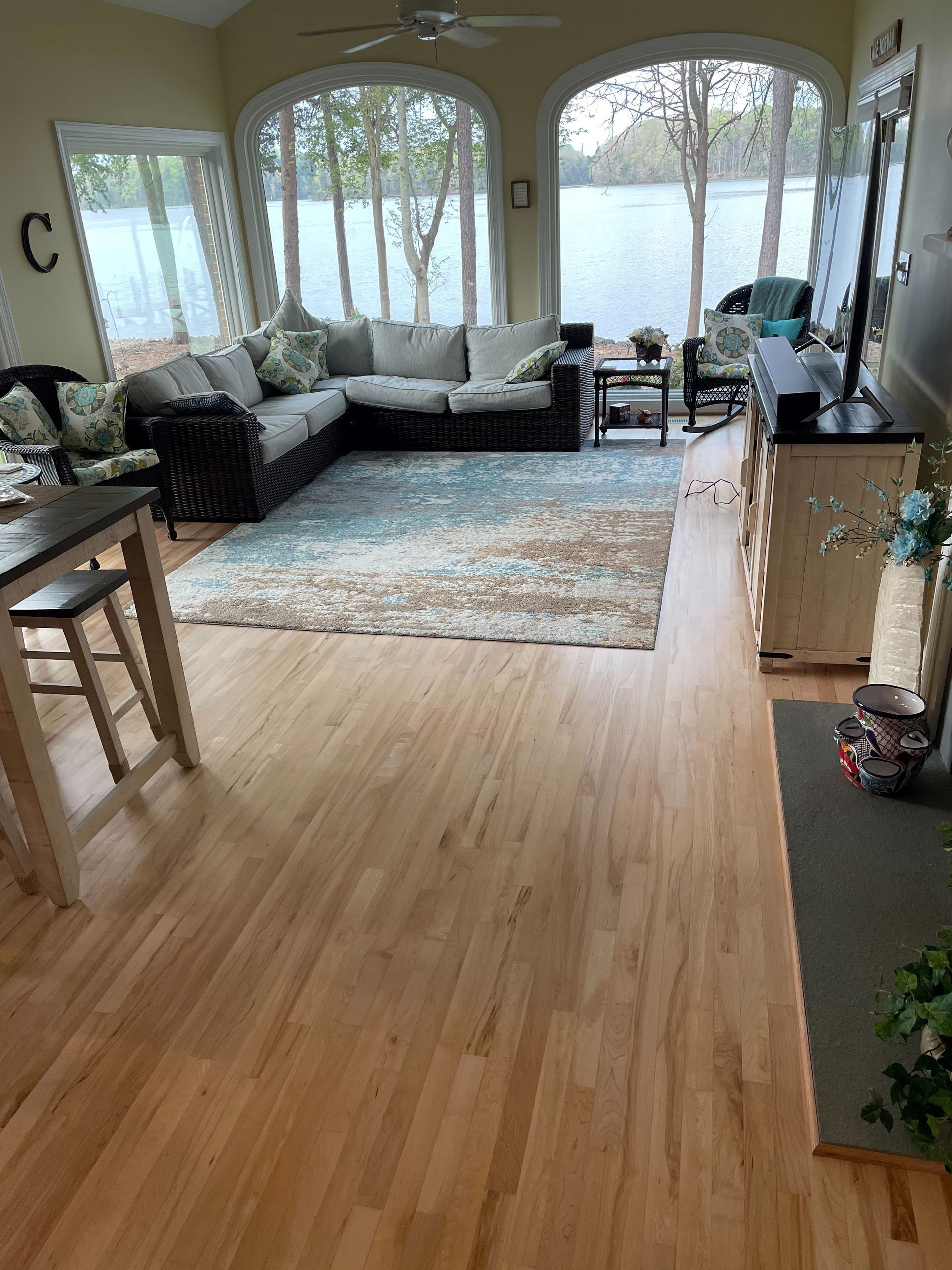 A living room with hardwood floors , a couch , a table , and a rug.