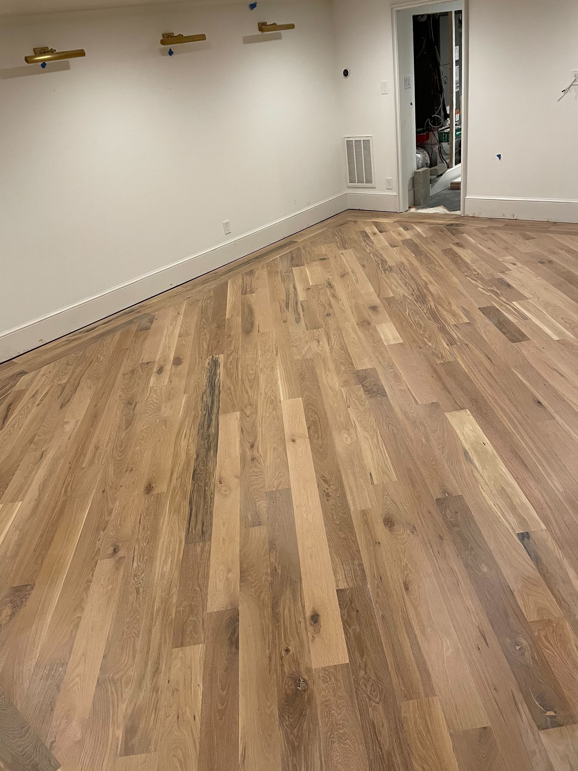 A room with a wooden floor and white walls.