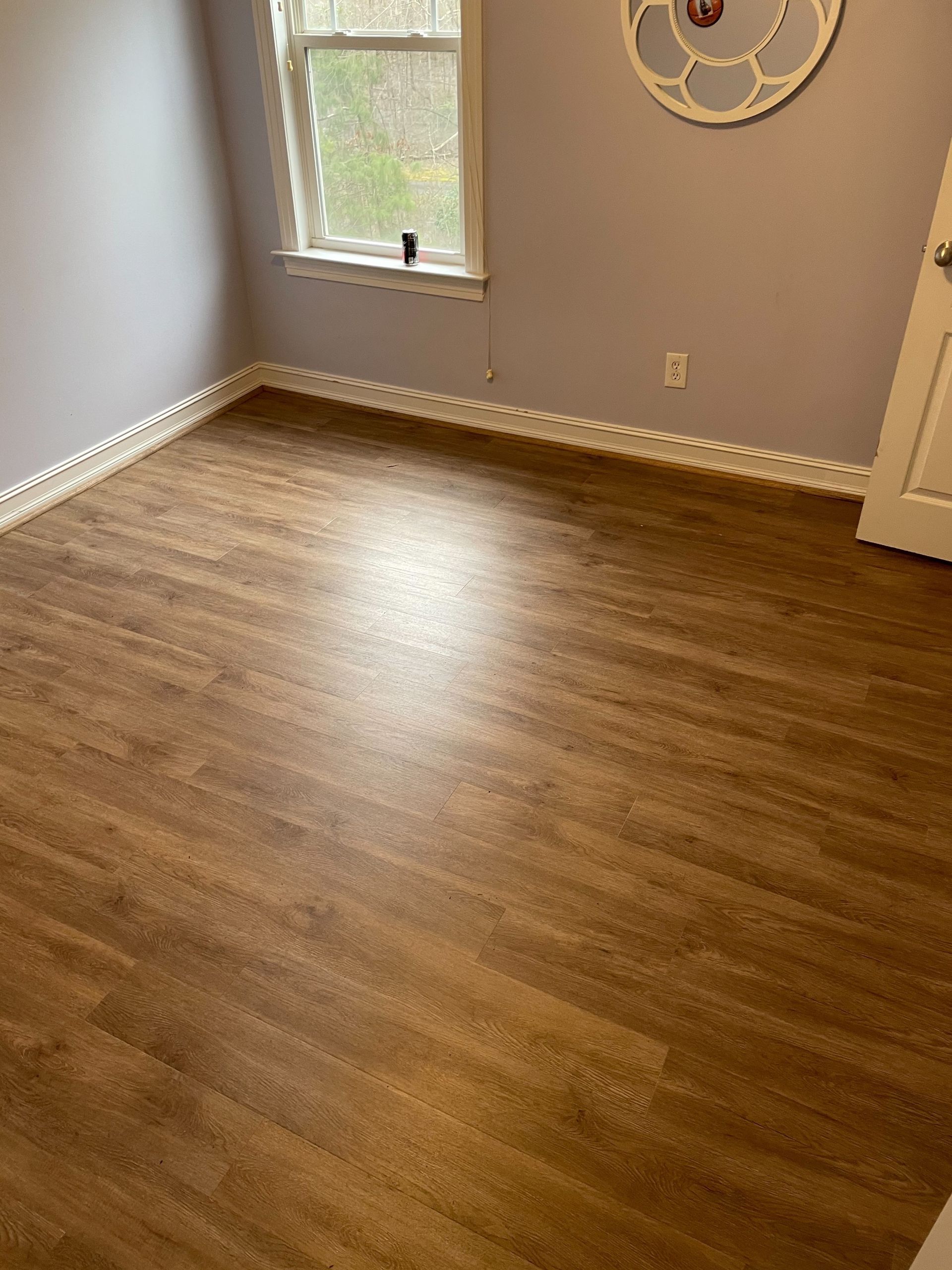 A room with a wooden floor and a window.