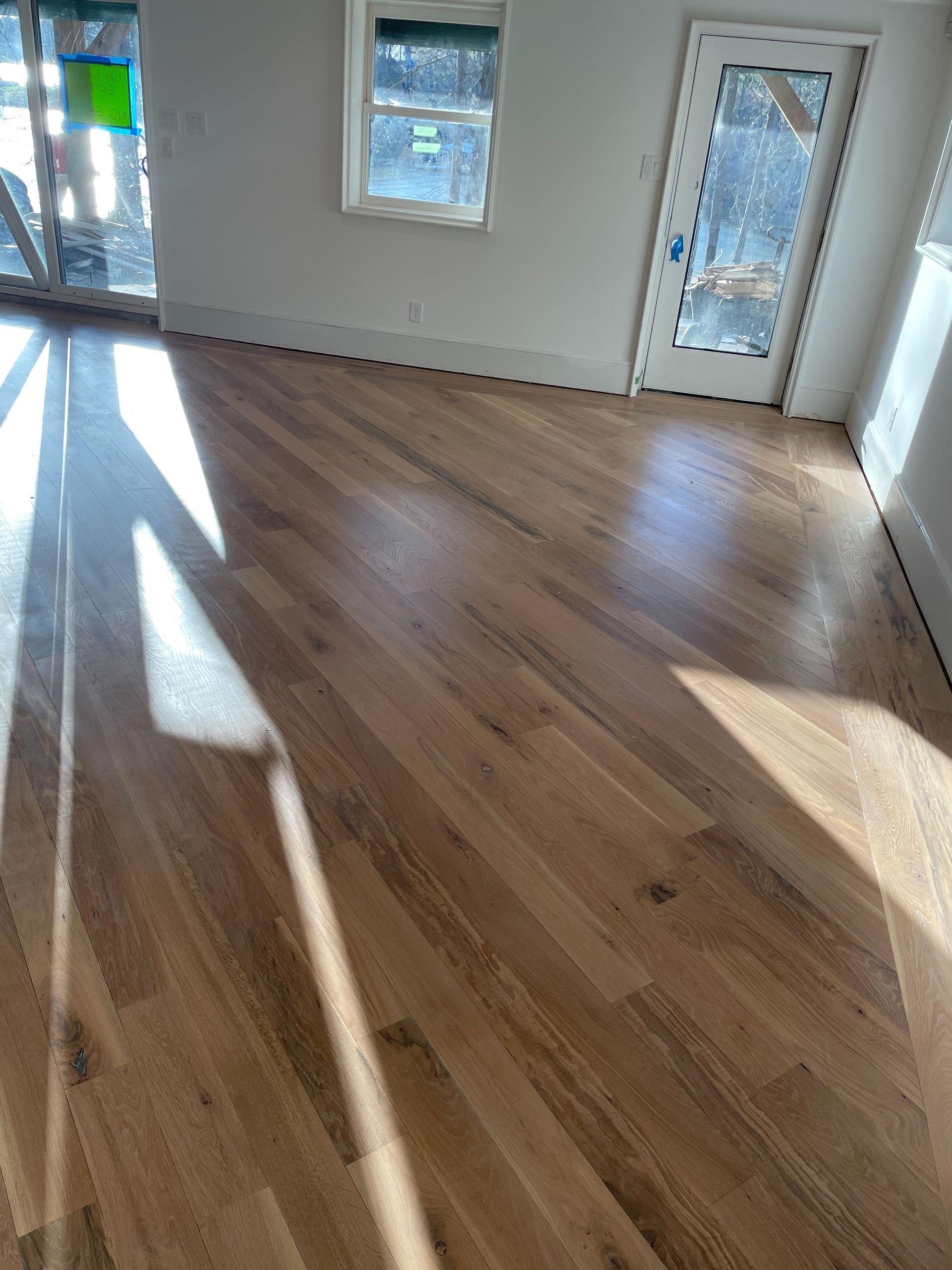 A living room with hardwood floors and a sliding glass door.