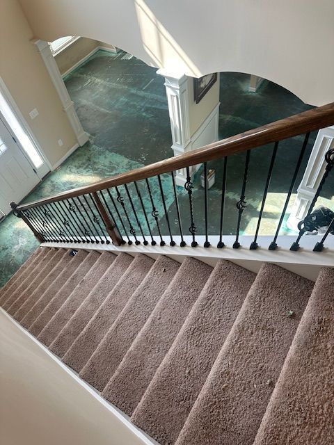 A staircase with a carpeted floor and a wooden railing