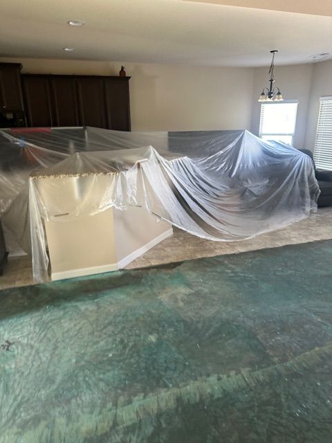 A living room with a couch and a table covered in plastic.