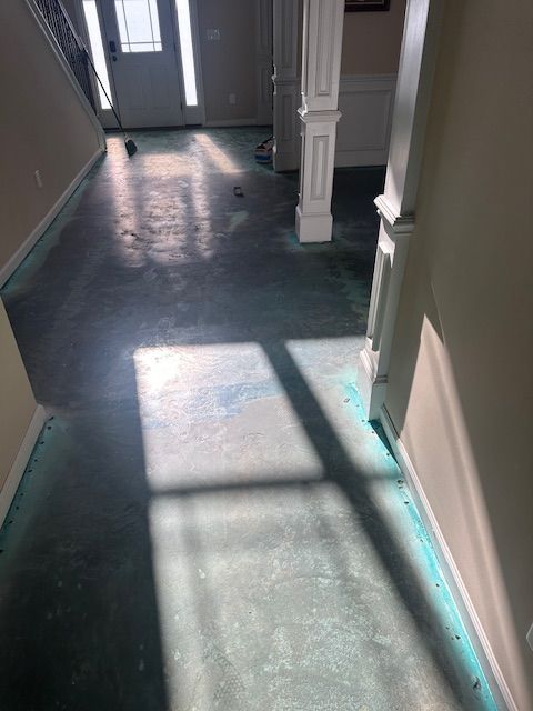 A hallway with a concrete floor and a white door.