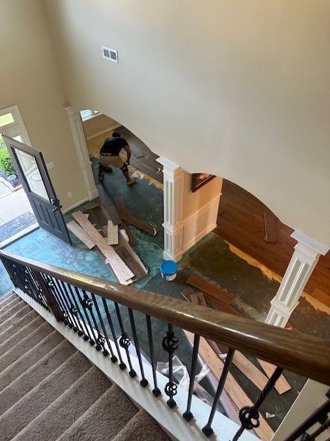 A man is working on a staircase in a house.