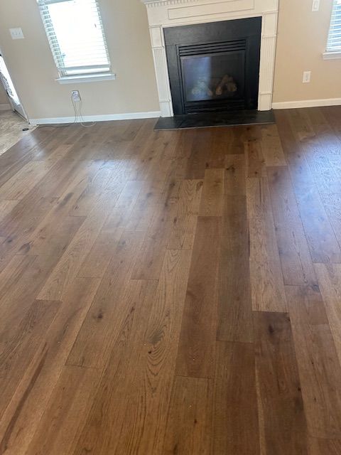 A living room with hardwood floors and a fireplace.