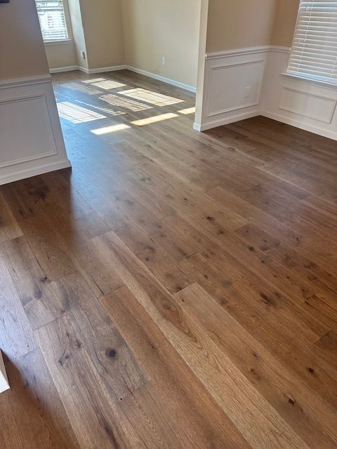 A living room with hardwood floors and a window.