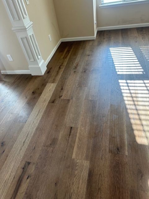 A living room with hardwood floors and a window.