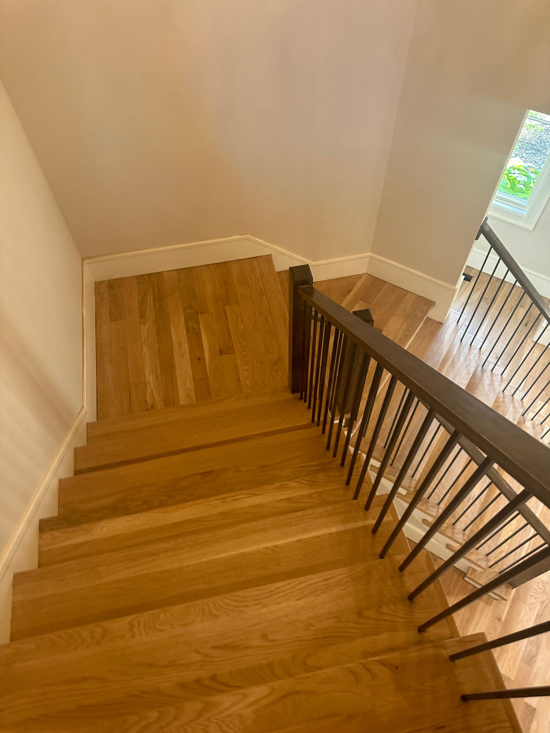 A wooden staircase with a metal railing in a house.