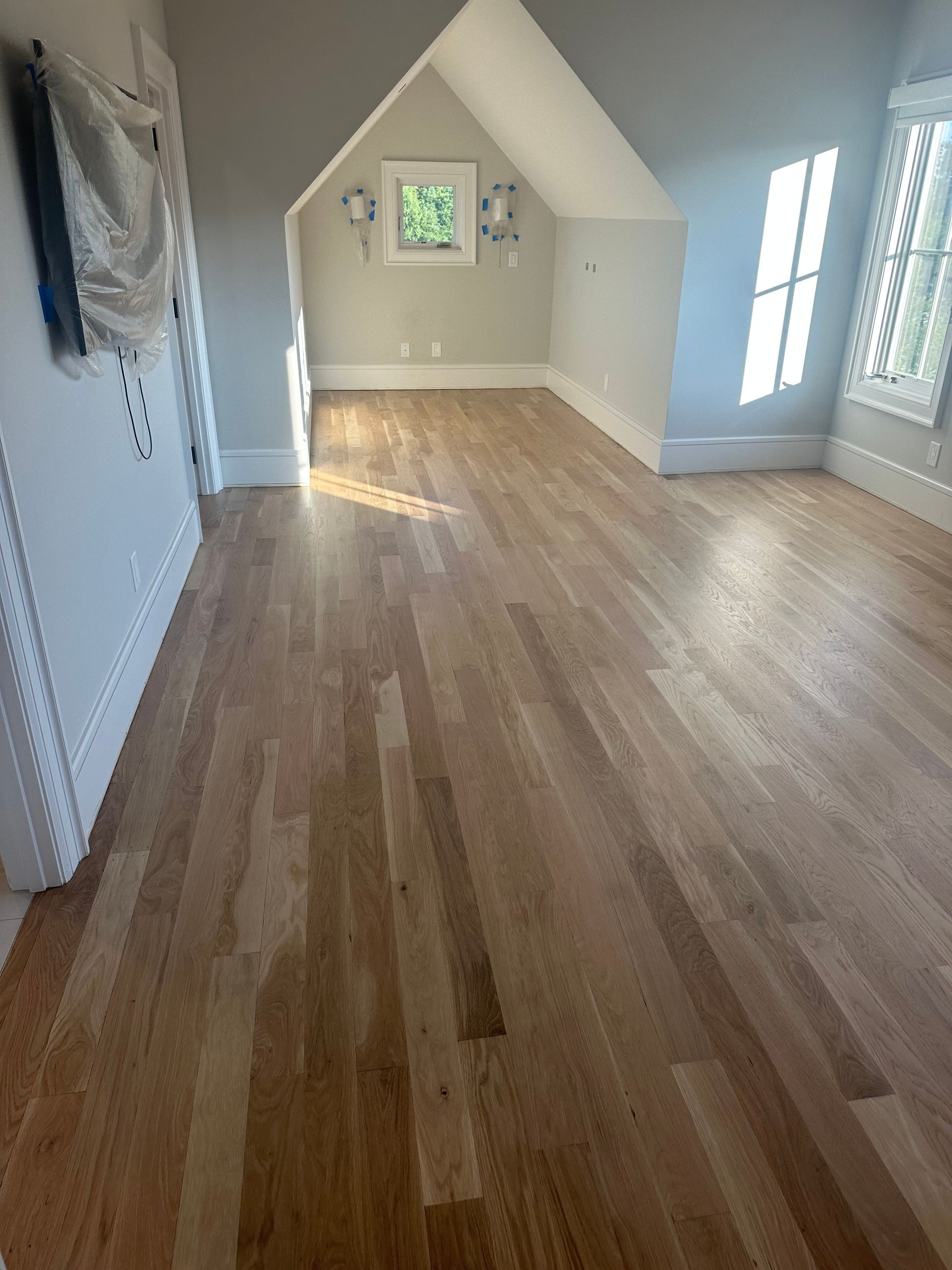 A room with hardwood floors and shutters in a house.
