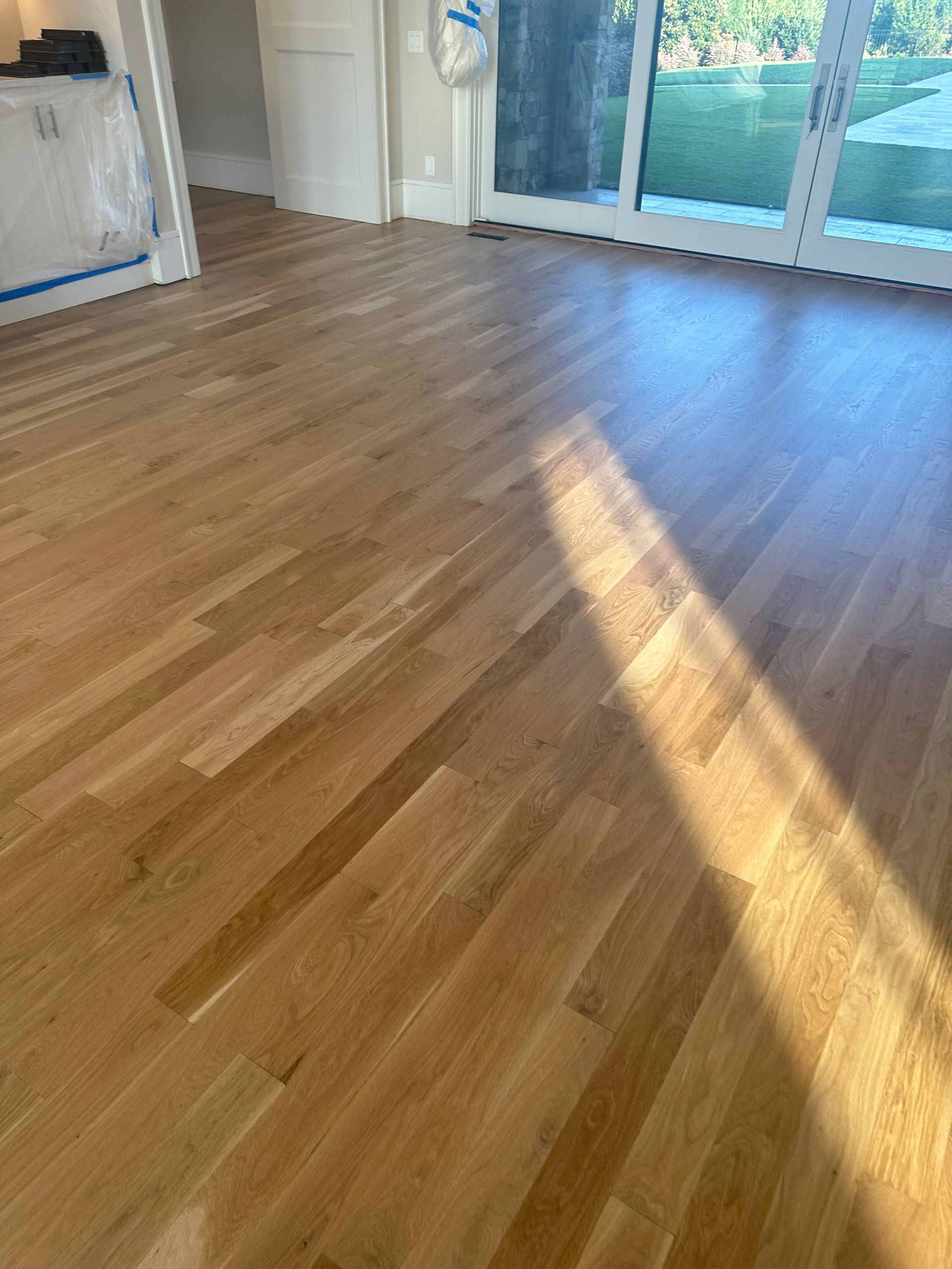 A living room with hardwood floors and a sliding glass door.