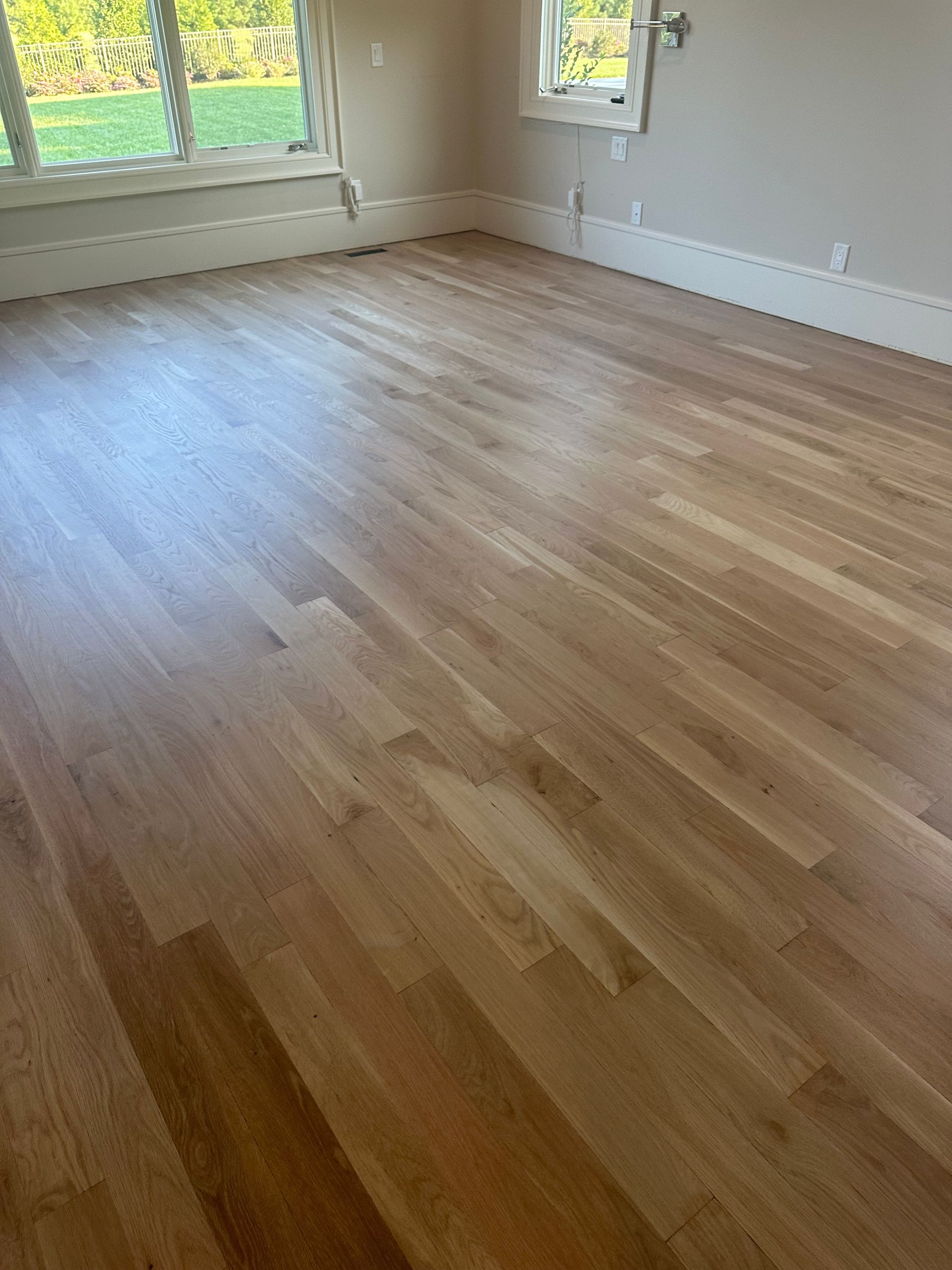 A living room with hardwood floors and a window.