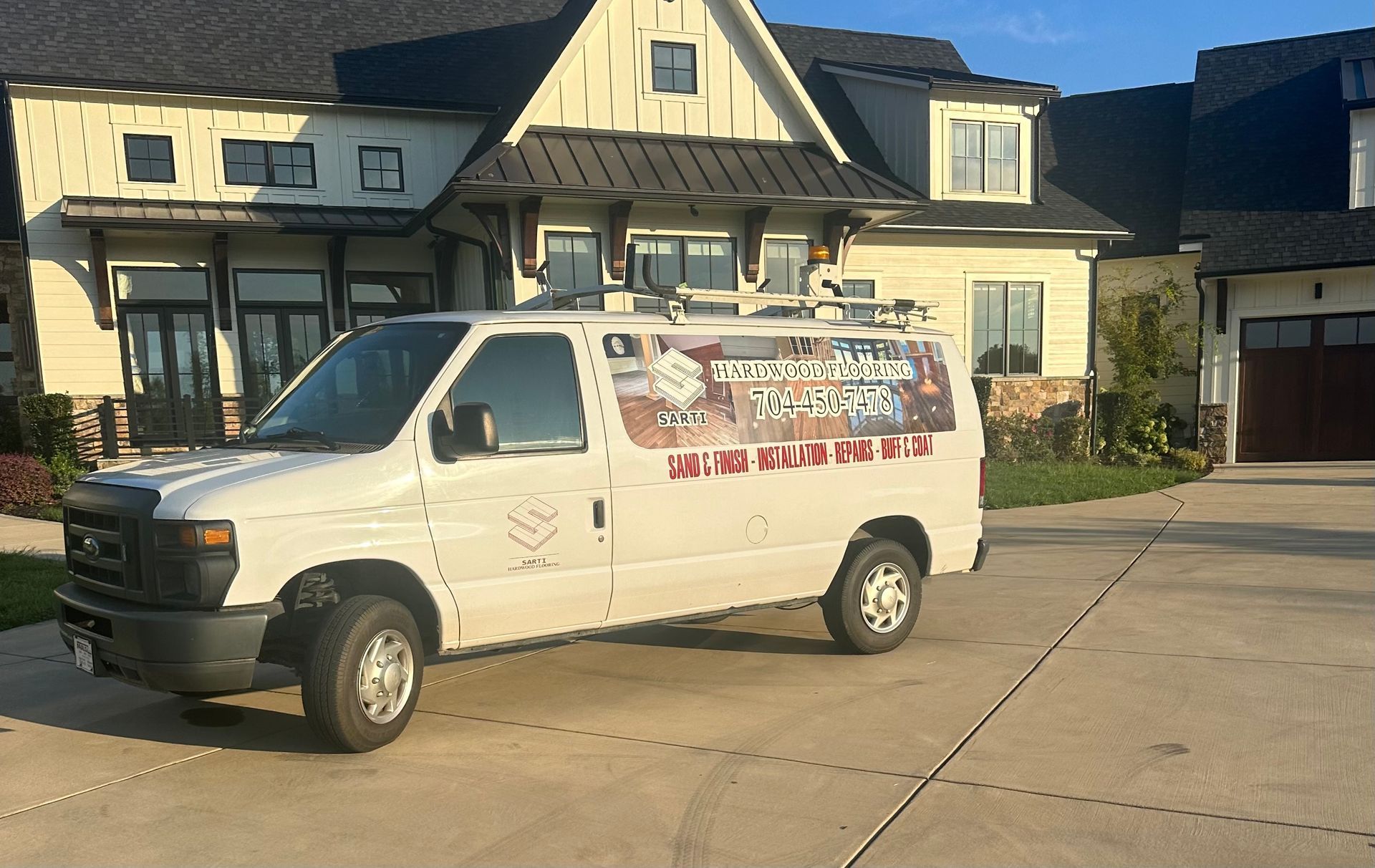 A white van is parked in front of a large house.