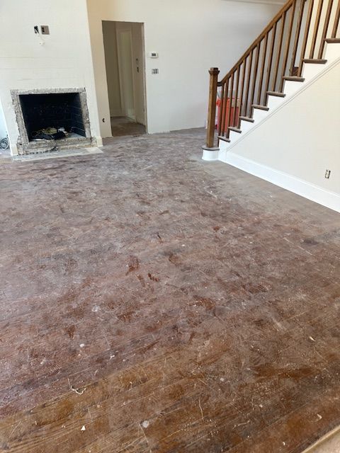 An empty living room with stairs and a fireplace.