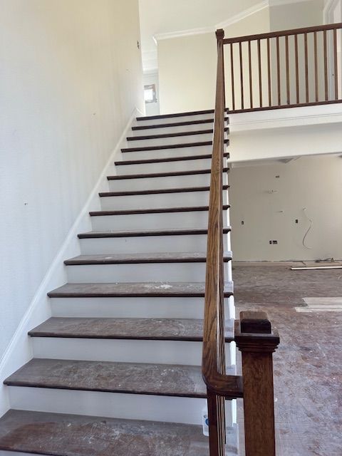A staircase with white steps and a wooden railing