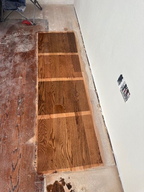 A wooden floor is being installed in a room.
