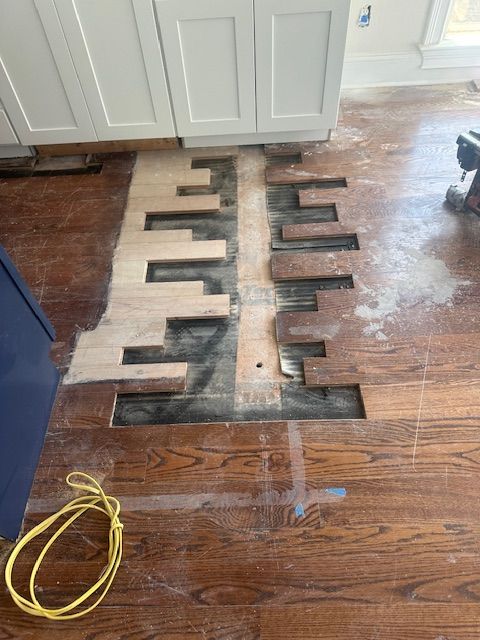A wooden floor is being installed in a kitchen.