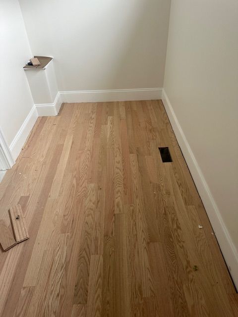 A room with hardwood floors and white walls.