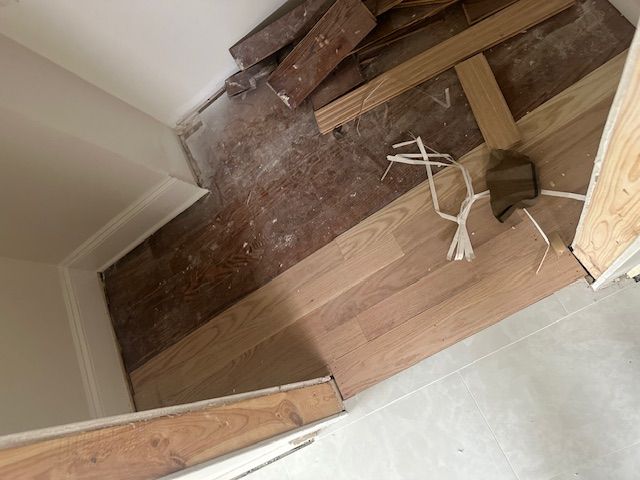 A wooden floor is being installed in a room.