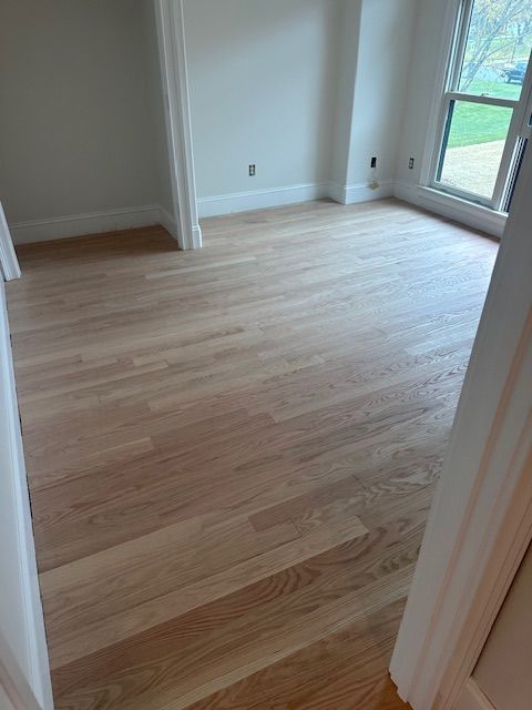 A room with hardwood floors and white walls.