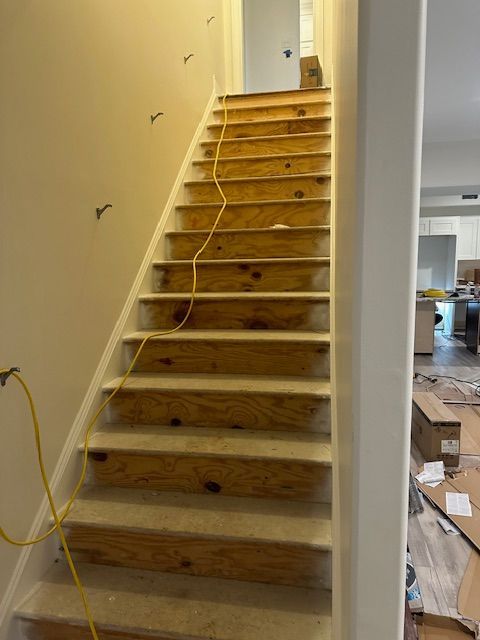 A wooden staircase is being built in a house.