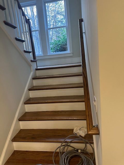 A staircase with wooden steps and a white railing in a house.