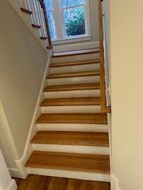 A staircase with wooden steps and white railing in a house.
