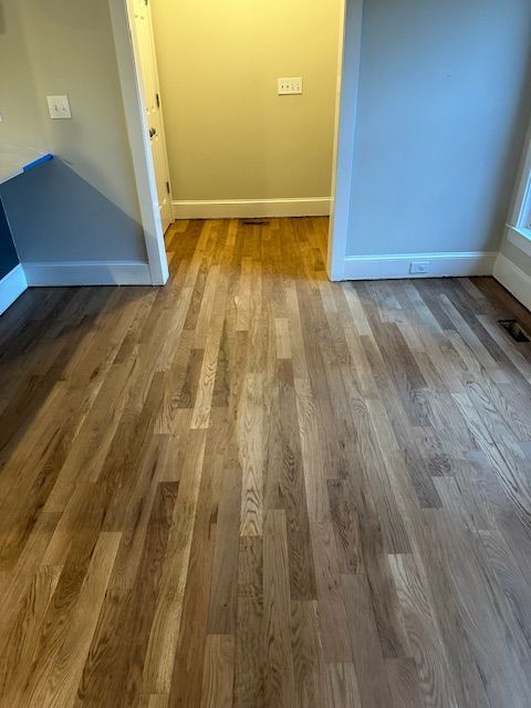 A room with hardwood floors and a doorway leading to a closet.