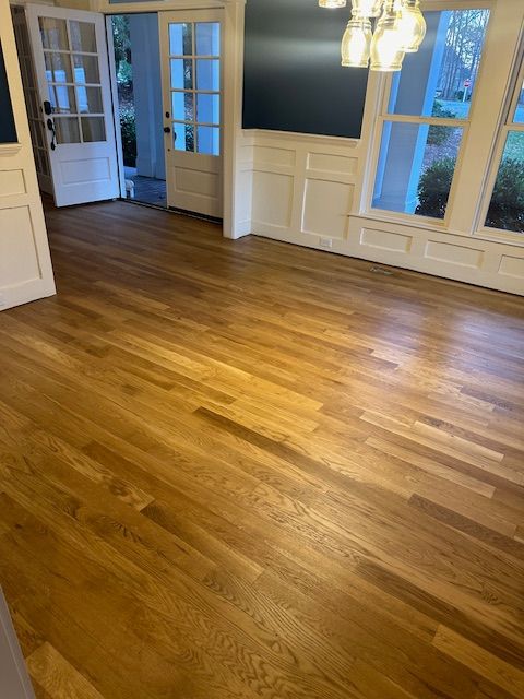 A living room with hardwood floors and white walls.