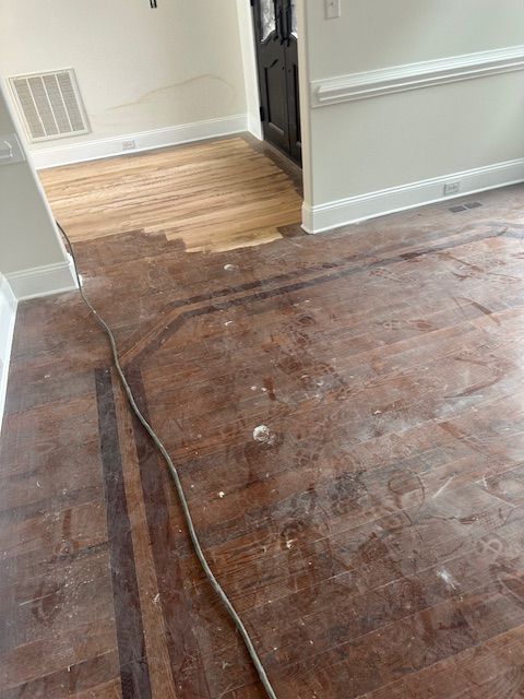 A wooden floor in a room with a cord hanging from it.