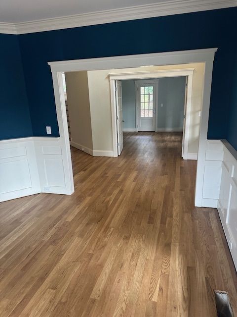An empty room with hardwood floors and blue walls
