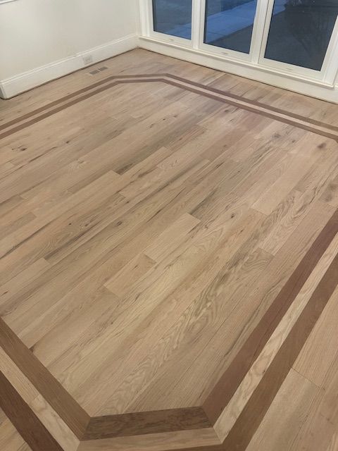A wooden floor with a wooden border in a room.