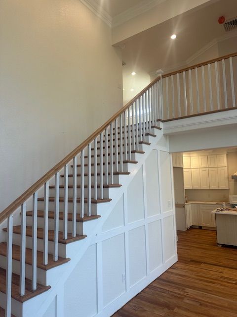 A white staircase with a wooden railing in a house