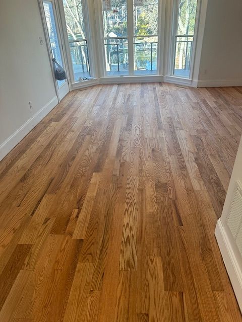 A living room with hardwood floors and lots of windows.