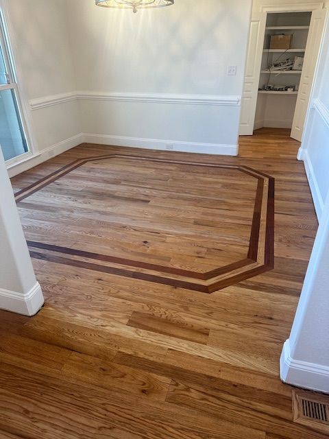 A dining room with a wooden floor and a wooden border.