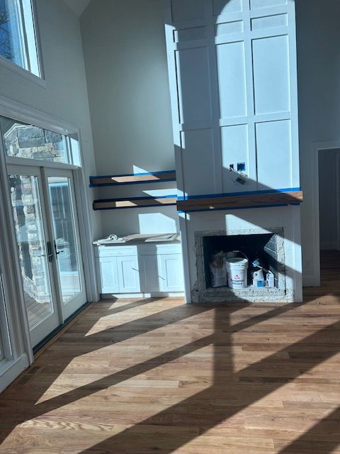A living room with hardwood floors and a fireplace.