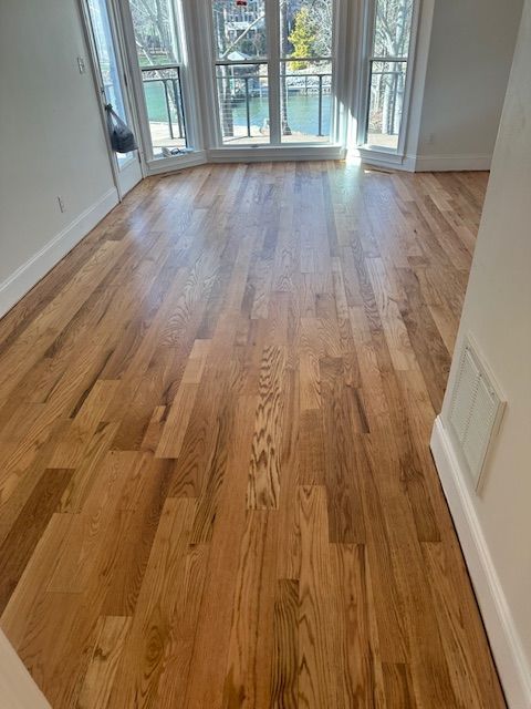 A living room with hardwood floors and a balcony.