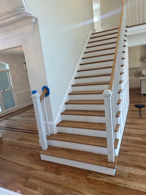 A white staircase with wooden steps in a house