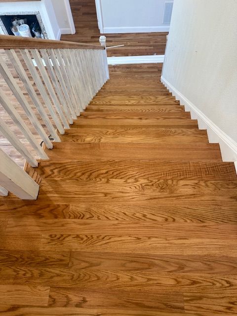 The stairs are made of hardwood and have a white railing.