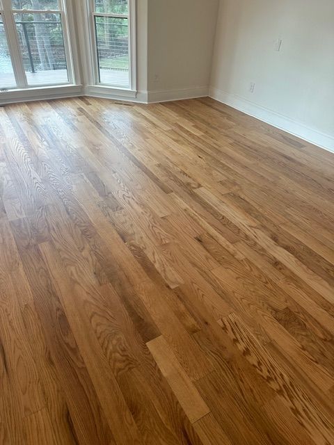 A living room with hardwood floors and a balcony.