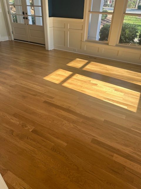 A living room with hardwood floors and a window.