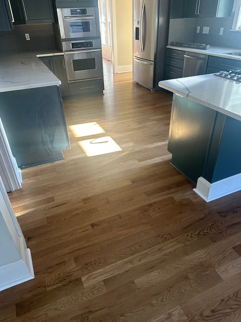 A kitchen with hardwood floors and stainless steel appliances.