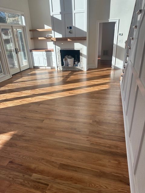 A living room with hardwood floors and a fireplace.