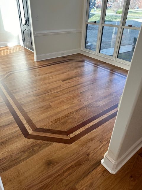 A living room with a wooden floor and a window.