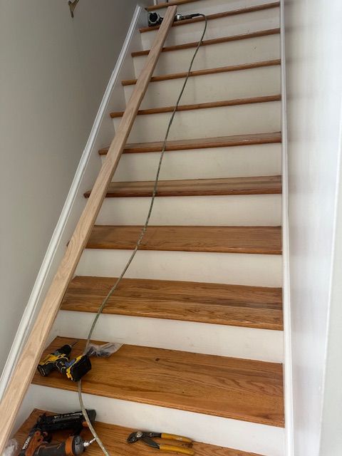 A wooden staircase with a drill and pliers on the steps