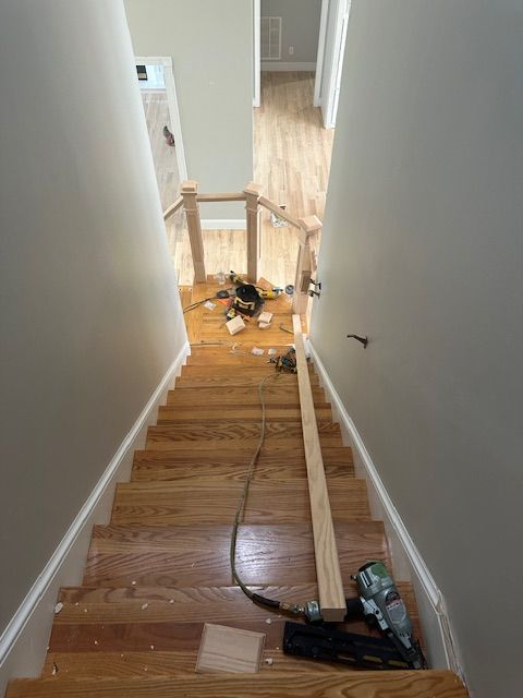 A wooden staircase is being built in a house.