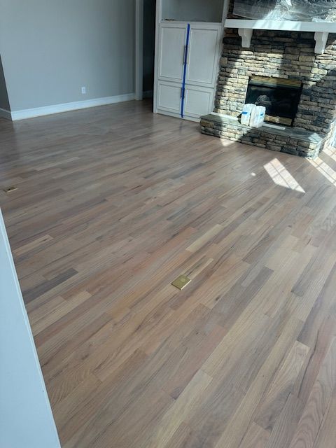 A living room with hardwood floors and a fireplace.