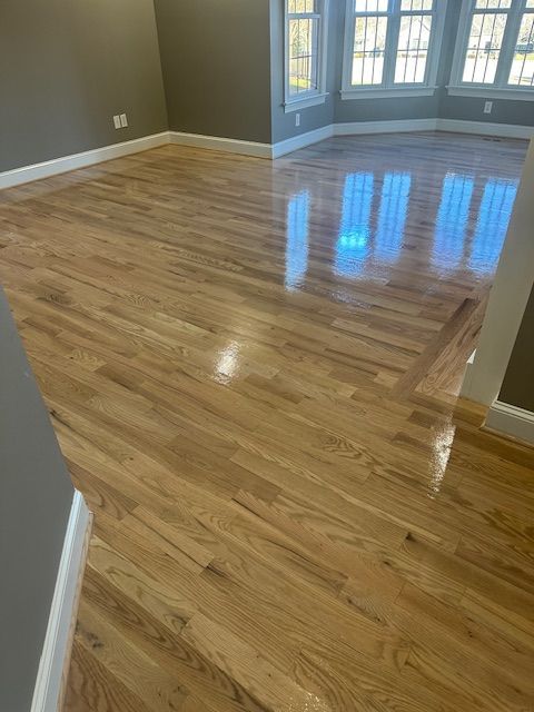 A living room with hardwood floors and a bay window.