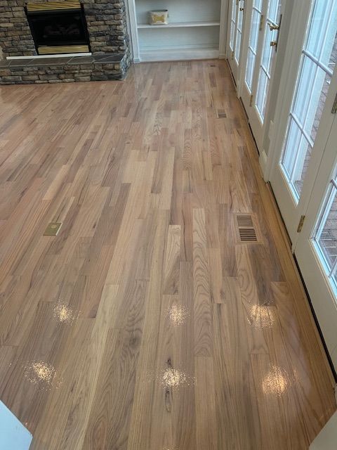 A living room with hardwood floors and a fireplace.